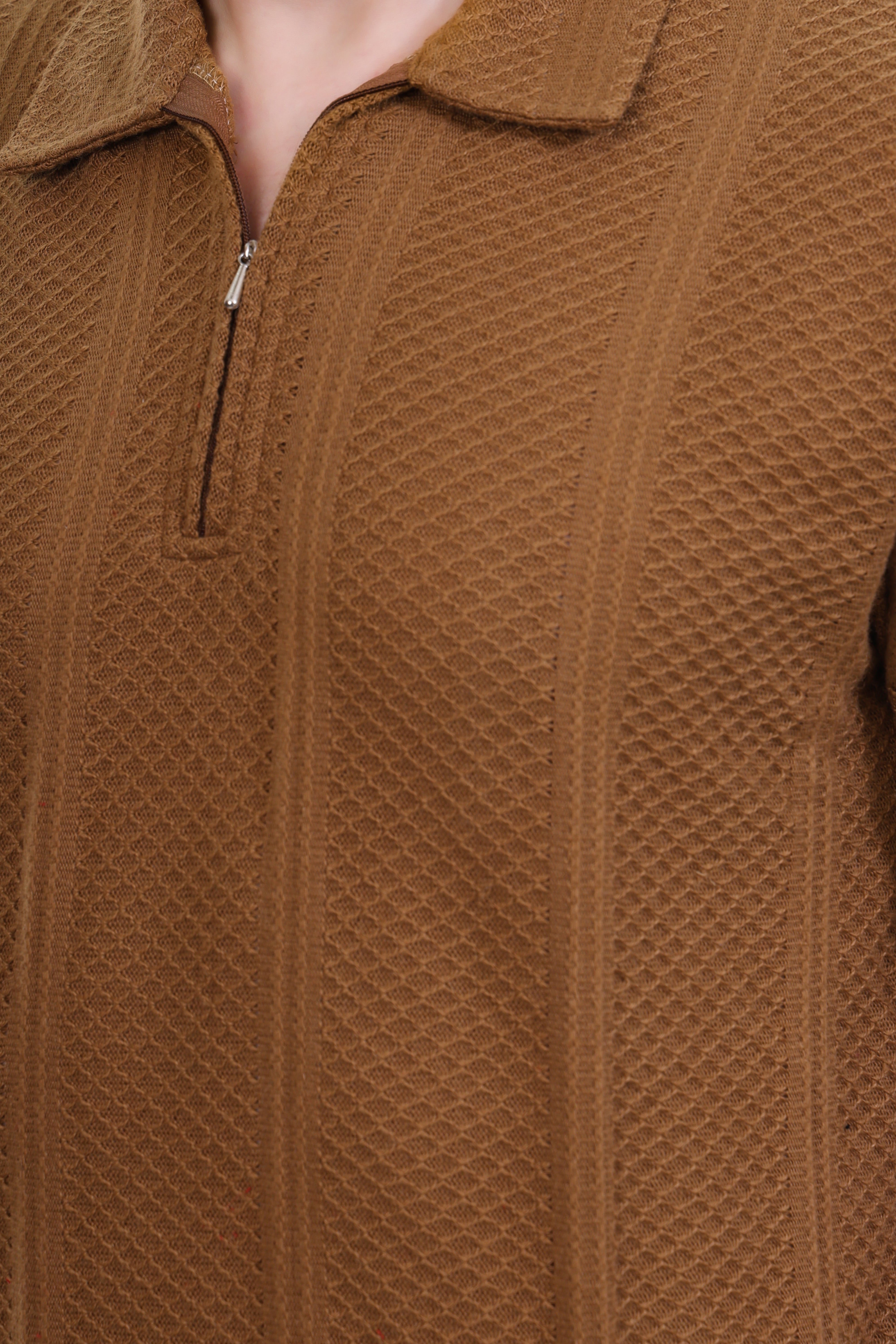 Close-up of a brown textured tshirt with a zipper.